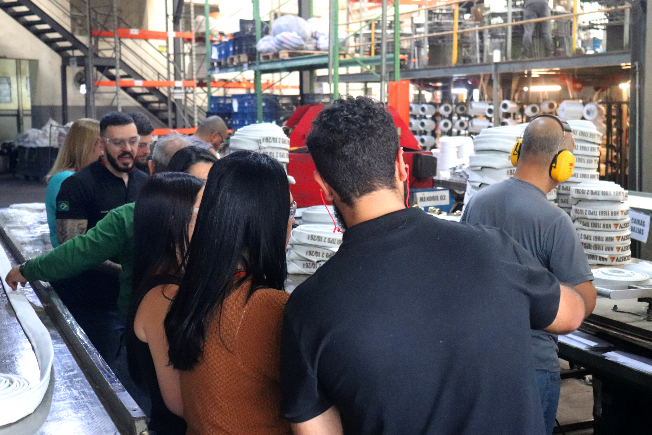 Visitantes conhecendo o setor de tecelagem e estoque de mangueiras Flexcasty